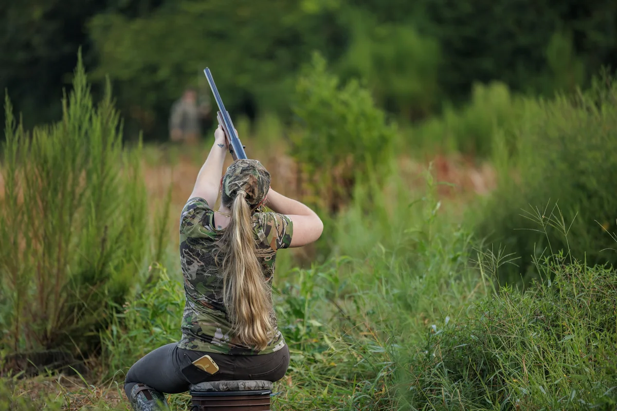 Hunter swinging on a passing dove over a September field