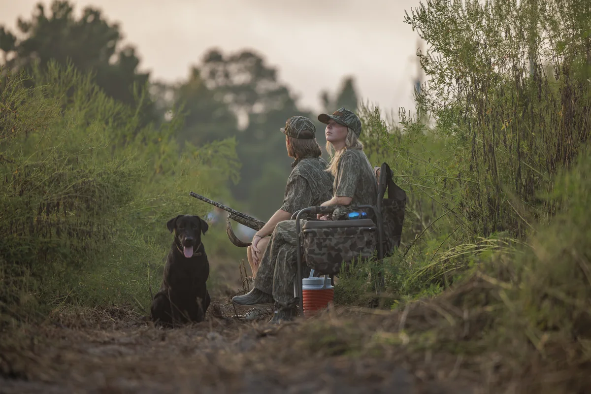Hunters and a black Labrador waiting out a dove field at first light